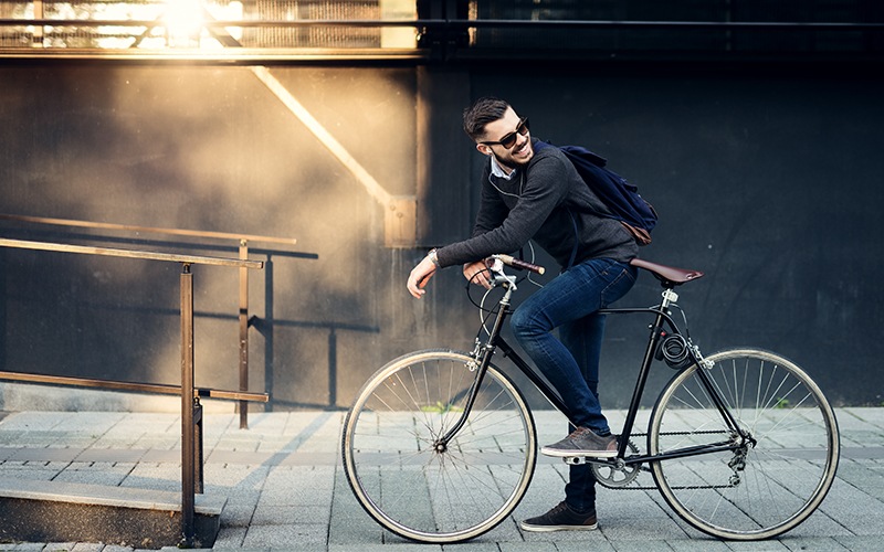 Man sitting on his bike on a sidewalk 